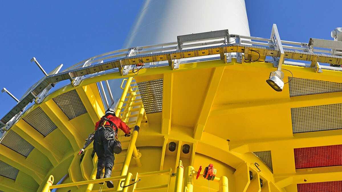 Engineer climbing offshore wind turbine transition piece.